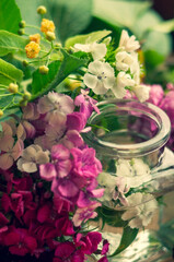 bouquet of flowers in a glass jar on a wooden background. place for text