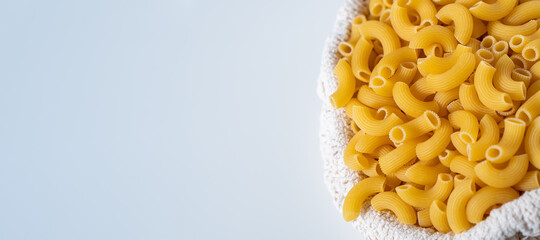 Raw dry uncooked Elbow Macaroni pasta spaghetti on white background. Good for basil tomato pesto sauce Homemade fresh Italian food organic whole wheat vegan spaghetti noodle for a healthy meal