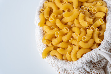 Raw dry uncooked Elbow Macaroni pasta spaghetti on white background. Good for basil tomato pesto sauce Homemade fresh Italian food organic whole wheat vegan spaghetti noodle for a healthy meal