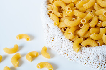 Raw dry uncooked Elbow Macaroni pasta spaghetti on white background. Good for basil tomato pesto sauce Homemade fresh Italian food organic whole wheat vegan spaghetti noodle for a healthy meal