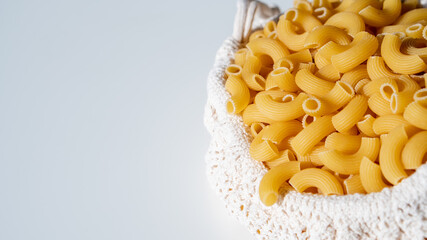 Raw dry uncooked Elbow Macaroni pasta spaghetti on white background. Good for basil tomato pesto sauce Homemade fresh Italian food organic whole wheat vegan spaghetti noodle for a healthy meal