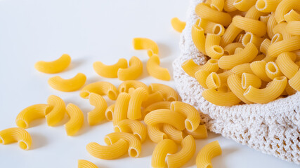 Raw dry uncooked Elbow Macaroni pasta spaghetti on white background. Good for basil tomato pesto sauce Homemade fresh Italian food organic whole wheat vegan spaghetti noodle for a healthy meal