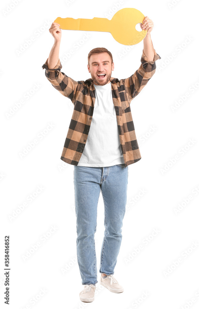 Poster Happy young man with big paper key on white background