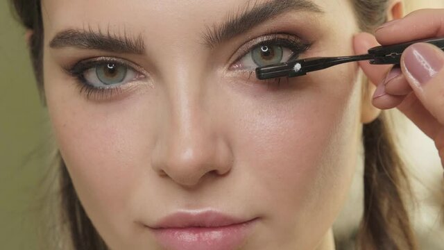 Makeup artist paints eyelash models in a makeup salon. Beauty face.