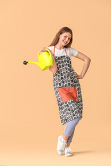 Young woman with watering can on color background