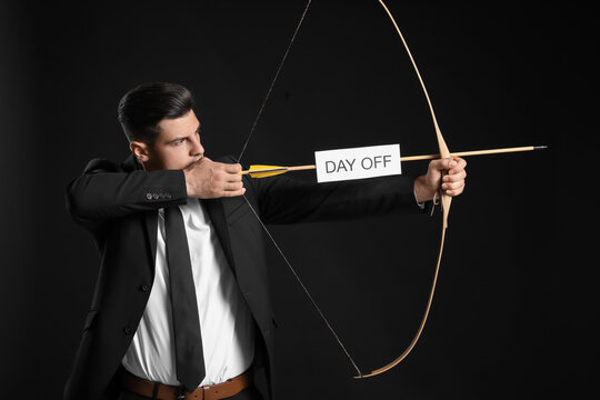 Businessman with crossbow and paper sheet with text DAY OFF on dark background