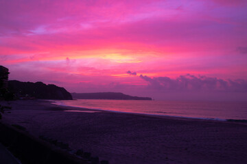 Pink Sunrise in Japan at the beach. Dawn early summer sky before a storm. Pacific ocean sky with headland