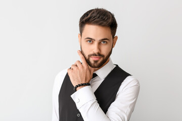 Young man in formal clothes on light background