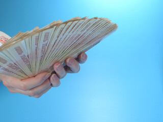Woman's hands holding many Russian ruble five thousand banknotes, side view, copy space