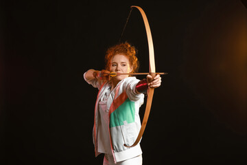 Beautiful female archer with bow on dark background