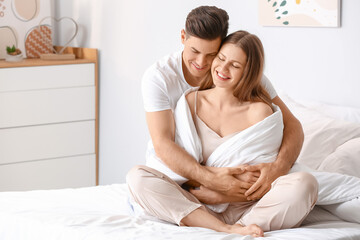 Morning of happy young couple in bed