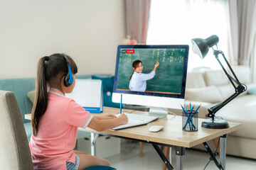 Asian  student girl video conference e-learning with teacher on computer in living room at home....