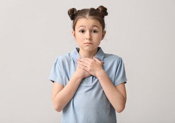 Apologizing little girl on light background