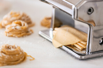 Preparing of pasta with machine on kitchen table