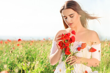 Beautiful young woman with poppy flowers in field