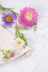 Beautiful, elegant dahlia flower over bright white marble table background, concept of Mother's Day flower gift, top view, flat lay, overhead