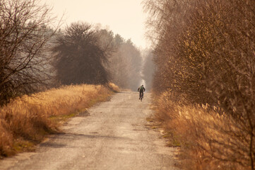 country road early spring. distant cyclist