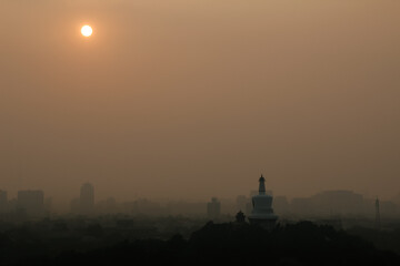 Sunset in Beijing, with the famous skyline and the White Pagoda, during a hot and polluted summer