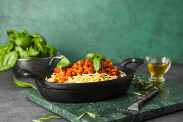 Frying pan with tasty pasta bolognese on table