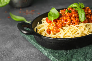 Frying pan with tasty pasta bolognese on table