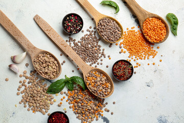 Spoons with lentils and spices on white background