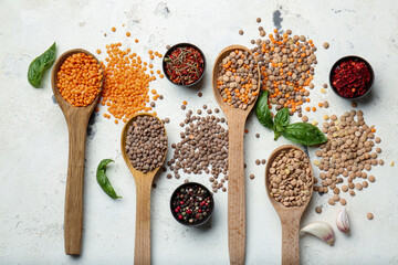 Spoons with lentils and spices on white background