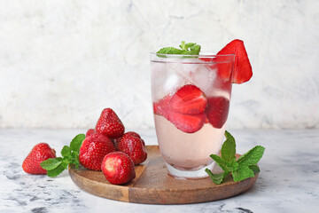 Glass of fresh strawberry lemonade on table