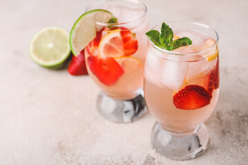 Glasses of fresh strawberry lemonade on table
