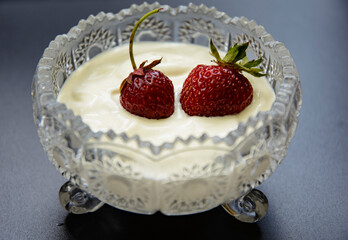 Strawberries in sour cream in a crystal cup - a delicious dessert.