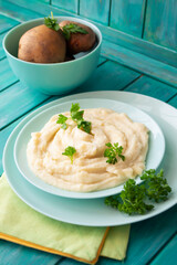 Mashed potatoes in bowl on blue teal wooden table