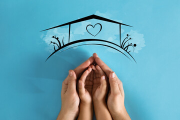 Mother holding hands with child and illustration of house on blue background, top view. Adoption...