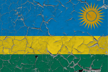 Rwanda flag close up grungy, damaged and scratched on wall peeling off paint to see inside surface. Vintage National Concept.