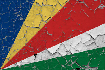 Seychelles flag close up grungy, damaged and scratched on wall peeling off paint to see inside surface. Vintage National Concept.