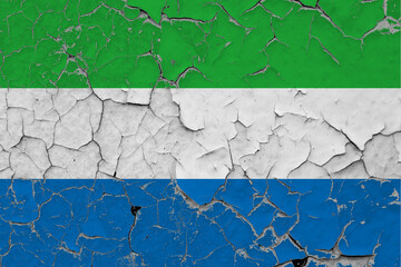 Sierra Leone flag close up grungy, damaged and scratched on wall peeling off paint to see inside surface. Vintage National Concept.