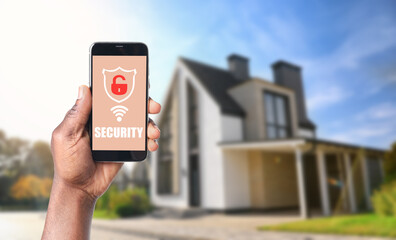 Alarm system. African-American man using phone outdoors, space for text