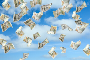 Falling American dollars and blue sky on background. Money rain