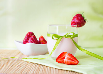 appetizing homemade strawberry smoothie in glass with bow and strawberry decoration