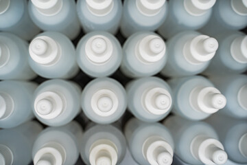 A lot of white bottles filled with liquid. Manufacture of antiseptics