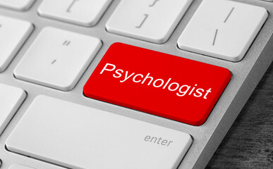 Fototapeta premium Modern computer keyboard with word PSYCHOLOGIST on table, closeup