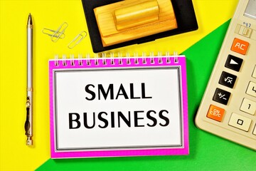 Small business-entrepreneurship of small firms. On the table is a calculator, a Commerce planning notebook, a pen for writing, and a stamp for contracts.