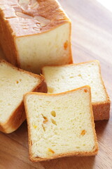 Sliced orange bread on wooden board with copy space