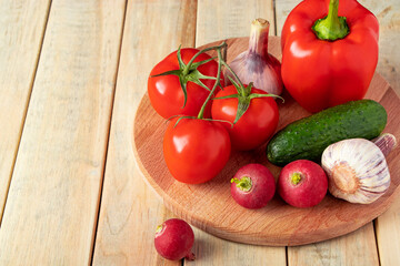 Set of fresh vegetables in a basket on a wooden background. The concept of healthy nutrition and diet.