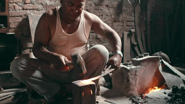 Rural blacksmith hammering a metal piece on an anvil