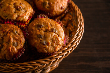 Freshly baked homemade muffins with raisins and carrots. Vegetarian pastries on a wooden background.