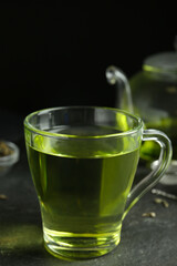 Cup of aromatic green tea on grey table