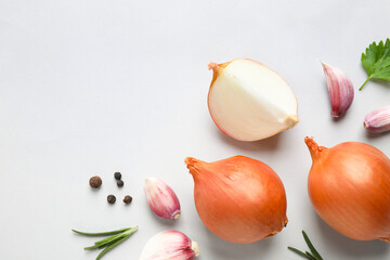 Flat lay composition with onions and spices on light background