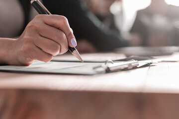 female hands with pen writing on notebook