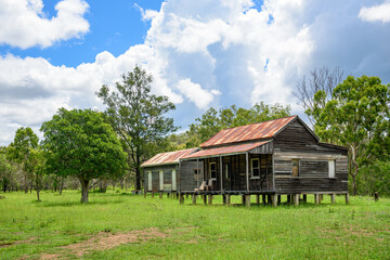 disused homestead in the middle of a green field in Kroombit Tops National Park, Queensland