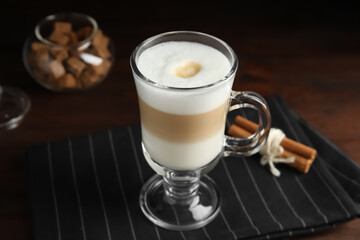 Delicious latte macchiato and cinnamon on table