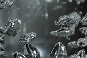 Drops and bubbles of mercury in water. Dangerous chemical element, the scientific experience.